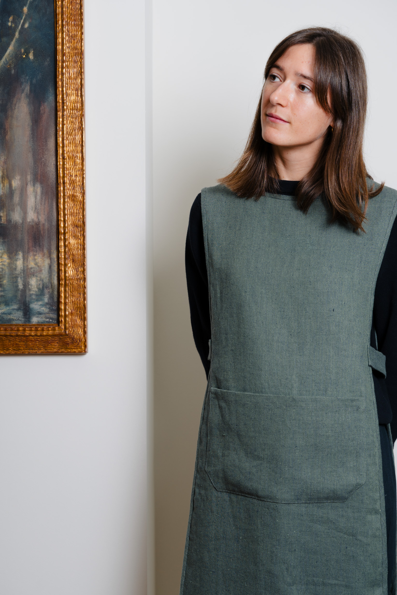 Professional work apron in green natural textile, minimalist uniform for hotel and restaurant staff