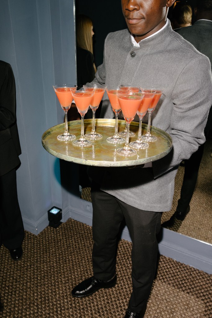 Hospitality staff interacting at a bar counter during service, refined restaurant interior